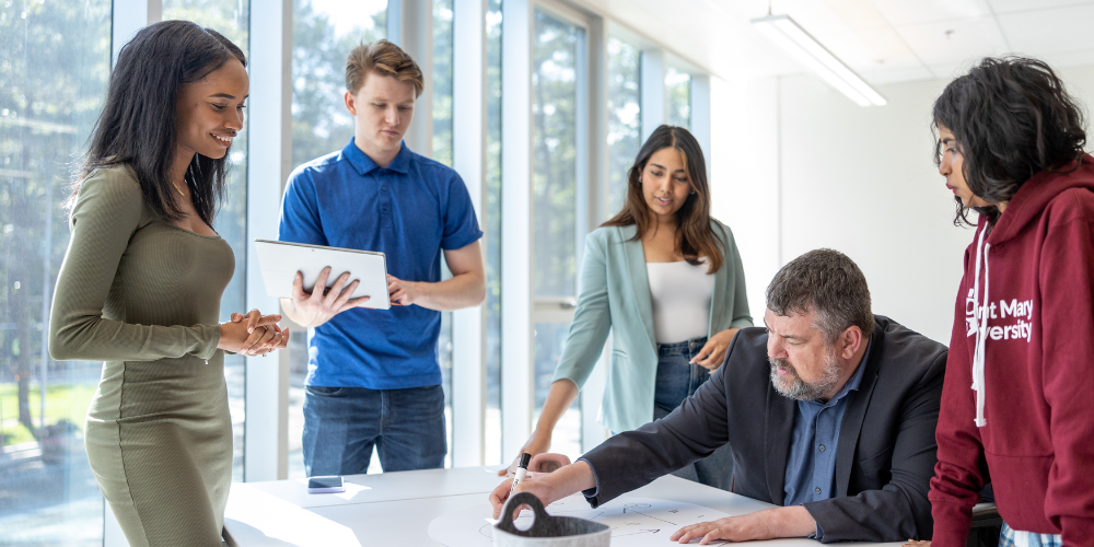 Students and staff from the entrepreneurship centre work together at a desk