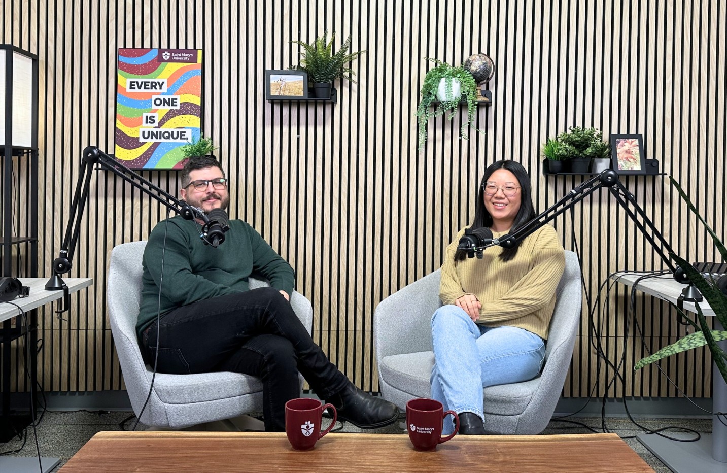 Two people sit in podcast studio