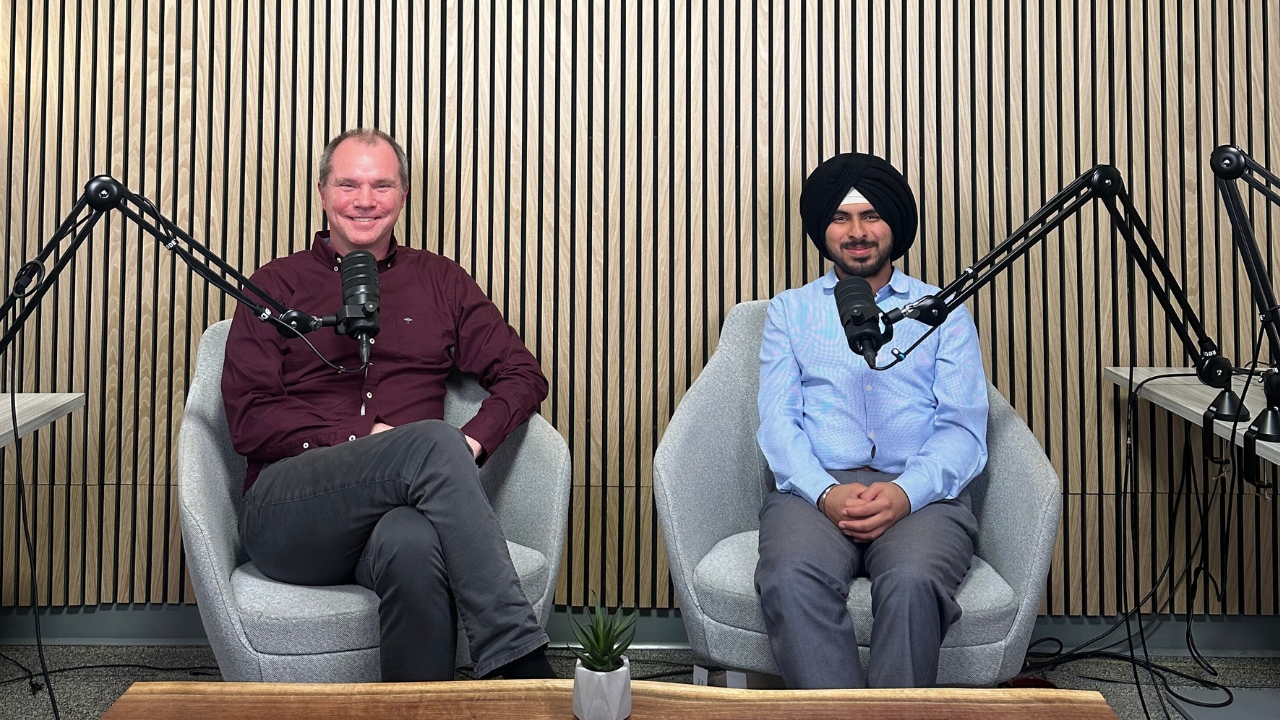 A professor and student sit together in the podcast studio